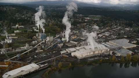 AX153_152.0000265F - Aerial stock photo of Steam rising from the Georgia Pacific Paper Mill in Camas, Washington