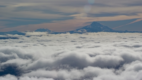 AX154_098.0000218F - Aerial stock photo of Mount Jefferson and the Three Sisters Volcanoes seen from across low clouds, Cascade Range, Oregon