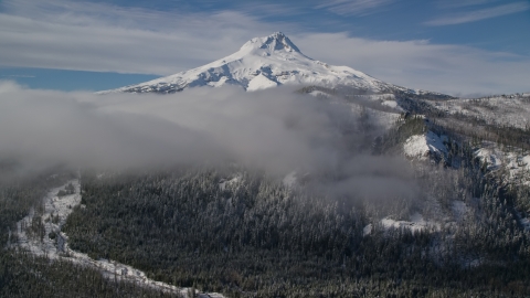 AX154_121.0000120F - Aerial stock photo of Low clouds over forest and ridge near snow-capped Mount Hood, Cascade Range, Oregon