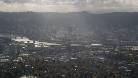 AX154_224.0000000F - Aerial stock photo of Godrays shining down on Moda Center, the Willamette River and Downtown Portland, Oregon