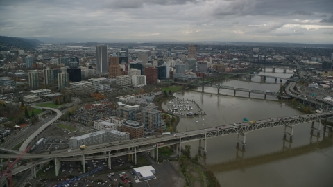 AX155_049.0000308F - Aerial stock photo of Marquam Bridge and Riverplace Marina near skyscrapers in Downtown Portland, Oregon