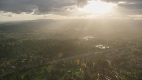 AX155_119.0000265F - Aerial stock photo of Godrays shining down on suburban neighborhoods and Highway 26, Southwest Portland, Oregon