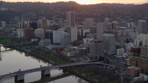 AX155_155.0000000F - Aerial stock photo of Downtown Portland skyscrapers and city park beside the Willamette River at sunset