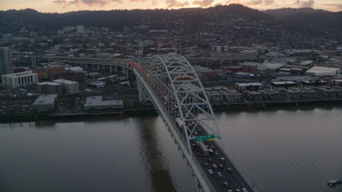 AX155_158.0000229F - Aerial stock photo of Heavy traffic crossing the Fremont Bridge at sunset in Downtown Portland, Oregon