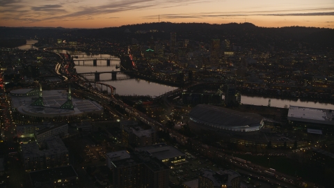 AX155_260.0000149F - Aerial stock photo of Moda Center, Willamette River, and downtown skyscrapers at sunset, Downtown Portland, Oregon