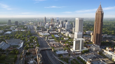 AX39_049.0000162F - Aerial stock photo of Downtown Connector along city buildings; Midtown Atlanta, Georgia