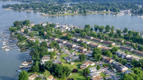 AXP073_000_0007F - Aerial stock photo of Row houses and riverfront homes with docks by Dark Head Creek and Middle River in Middle River, Maryland
