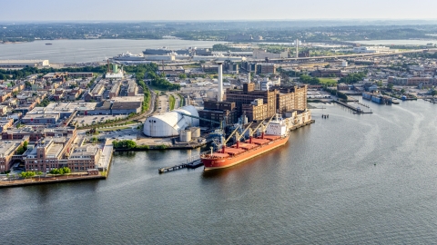 AXP073_000_0016F - Aerial stock photo of Cargo ship docked by the Domino Sugar Factory, Baltimore, Maryland