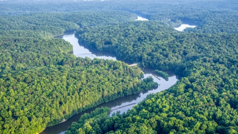AXP075_000_0028F - Aerial stock photo of A bridge spanning a river through dense forest near Manassas, Virginia