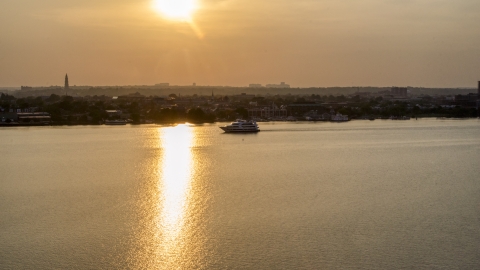 AXP076_000_0002F - Aerial stock photo of A ferry sailing the Potomac River, Alexandria, Virginia, sunset