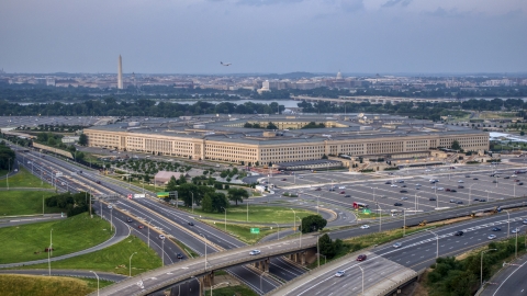 AXP076_000_0024F - Aerial stock photo of The Pentagon at twilight in Washington, D.C., with the Washington Monument in the distance