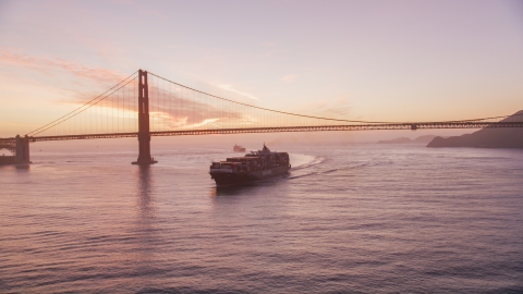 DCSF10_041.0000043 - Aerial stock photo of A cargo ship sailing by the Golden Gate Bridge, San Francisco, California, twilight