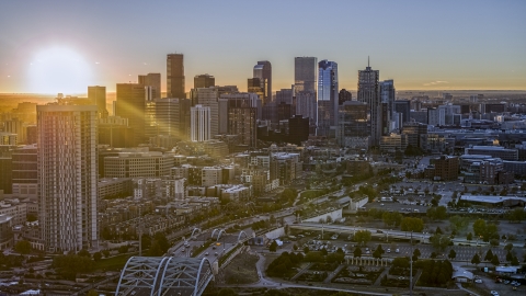 DXP001_000095 - Aerial stock photo of Sun rising behind the city's skyline and a residential skyscraper in Downtown Denver, Colorado