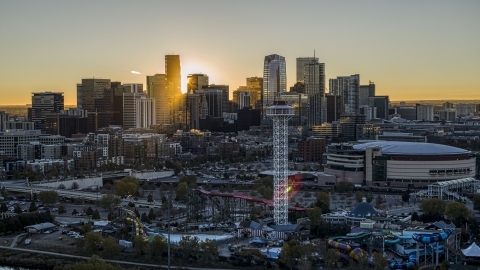 DXP001_000098 - Aerial stock photo of Bright sun rising behind the city's skyline, Elitch Gardens and Pepsi Center arena in Downtown Denver, Colorado