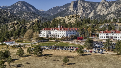 DXP001_000208 - Aerial stock photo of The historic Stanley Hotel with mountains behind it in Estes Park, Colorado