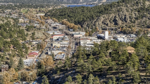 DXP001_000225 - Aerial stock photo of Shops on a road through Estes Park, Colorado, seen from a tree-covered hill