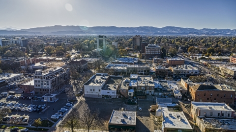 DXP001_000234 - Aerial stock photo of Shops with taller office buildings and mountains in the background in Fort Collins, Colorado