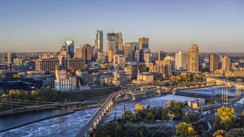 DXP001_000355 - Aerial stock photo of The city's skyline seen from the Stone Arch Bridge spanning the river at sunrise, Downtown Minneapolis, Minnesota