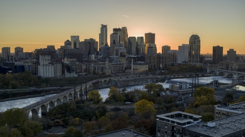 DXP001_000427 - Aerial stock photo of The city skyline across the river at sunset, seen from the Stone Arch Bridge, Downtown Minneapolis, Minnesota