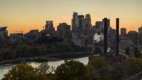 DXP001_000436 - Aerial stock photo of The downtown skyline at sunset, seen from smoke stacks by the river, Downtown Minneapolis, Minnesota