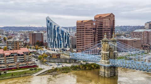 DXP001_000466 - Aerial stock photo of Condo complex and two office buildings behind the Roebling Bridge spanning Ohio River in Covington, Kentucky