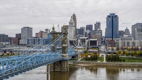 DXP001_000471 - Aerial stock photo of The side of the Roebling Bridge with Ferris wheel and skyline in the background, Downtown Cincinnati, Ohio