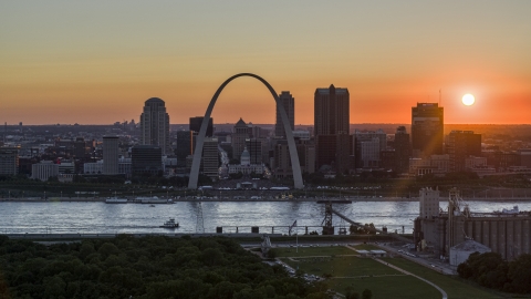 DXP001_029_0005 - Aerial stock photo of The setting sun behind the Gateway Arch and Downtown St. Louis, Missouri