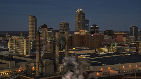 DXP001_093_0001 - Aerial stock photo of Smoke stacks and a view of city skyline at twilight in Downtown Indianapolis, Indiana