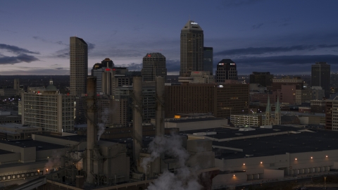 DXP001_093_001 - Aerial stock photo of Smoke stacks and a view of city skyline at twilight in Downtown Indianapolis, Indiana