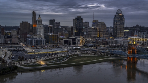 DXP001_097_0015 - Aerial stock photo of The city skyline and bridge lit at sunset, seen from Ohio River, Downtown Cincinnati, Ohio