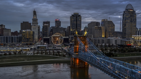 DXP001_097_0016 - Aerial stock photo of A view of the city skyline and Ferris wheel at sunset, seen from bridge and Ohio River, Downtown Cincinnati, Ohio