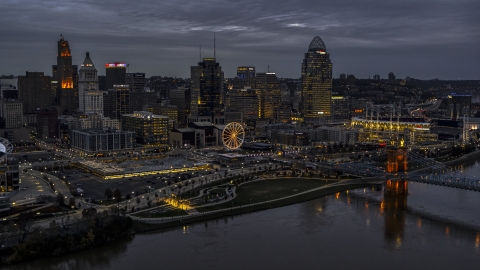 DXP001_098_0001 - Aerial stock photo of The city skyline and bridge lit for twilight, seen from Ohio River, Downtown Cincinnati, Ohio