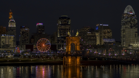 DXP001_098_0022 - Aerial stock photo of Ferris wheel, Roebling Bridge and city skyline at night, Downtown Cincinnati, Ohio
