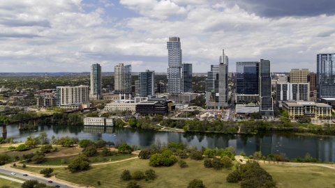 DXP002_102_0014 - Aerial stock photo of Tall city skyscrapers across Lady Bird Lake, Downtown Austin, Texas