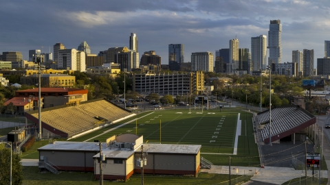 DXP002_105_0003 - Aerial stock photo of A view of skyscrapers from a football field at sunset in Downtown Austin, Texas