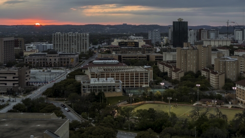 DXP002_105_0015 - Aerial stock photo of A view of the university campus with setting sun in distance, Austin, Texas