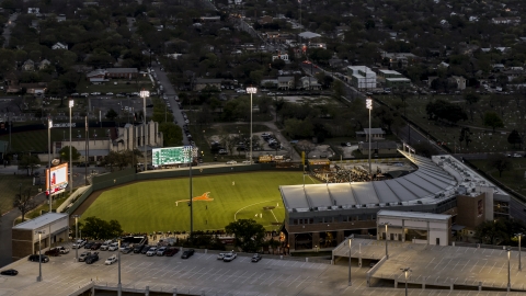 DXP002_105_0018 - Aerial stock photo of A baseball game at a stadium at the University of Texas at twilight, Austin, Texas