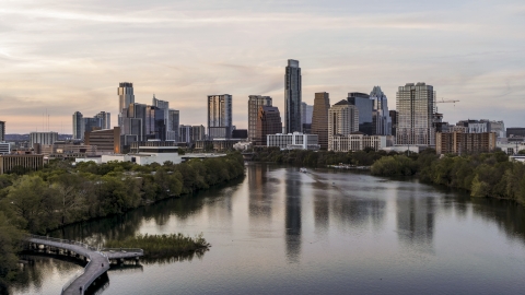 DXP002_110_0004 - Aerial stock photo of The city's skyline seen from low over Lady Bird Lake at sunset in Downtown Austin, Texas
