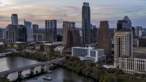 DXP002_110_0008 - Aerial stock photo of The Austonian in city skyline by Lady Bird Lake at twilight in Downtown Austin, Texas