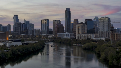 DXP002_110_0012 - Aerial stock photo of A view of the tall Austonian skyscraper and city skyline seen fro, over Lady Bird Lake at twilight in Downtown Austin, Texas