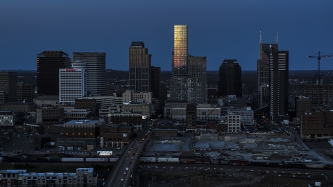 DXP002_115_0002 - Aerial stock photo of Light reflecting off skyscrapers in city's skyline, seen from Church Street at twilight in Downtown Nashville, Tennessee