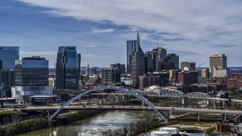 DXP002_116_0011 - Aerial stock photo of A river and bridge, skyscrapers in the background in Downtown Nashville, Tennessee