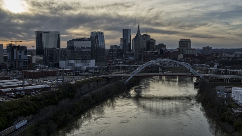 DXP002_119_0010 - Aerial stock photo of The city skyline behind a bridge on Cumberland River at sunset, Downtown Nashville, Tennessee