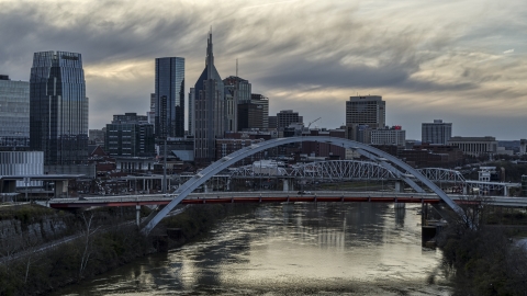 DXP002_120_0004 - Aerial stock photo of A view of riverfront skyline near a bridge and the Cumberland River at sunset, Downtown Nashville, Tennessee
