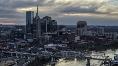 DXP002_120_0006 - Aerial stock photo of Riverfront skyline, pedestrian bridge, and Cumberland River at sunset, Downtown Nashville, Tennessee