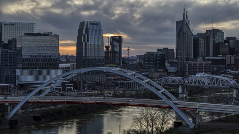 DXP002_120_0009 - Aerial stock photo of A tall skyscraper seen from a bridge on the river at sunset, Downtown Nashville, Tennessee