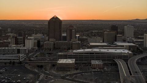 DXP002_122_0009 - Aerial stock photo of Sunset behind office tower and shorter hotel tower, Downtown Albuquerque, New Mexico