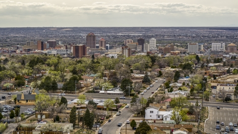 DXP002_126_0005 - Aerial stock photo of Wide view of city's high-rises seen while flying by homes, Downtown Albuquerque, New Mexico