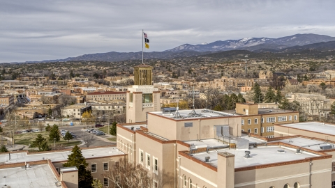 DXP002_131_0008 - Aerial stock photo of The tower and flags on Bataan Memorial Building, Santa Fe, New Mexico