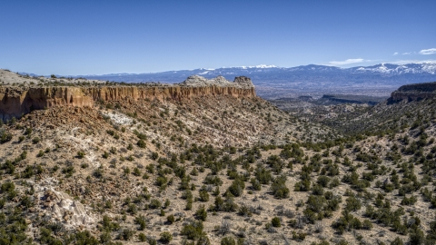 DXP002_133_0007 - Aerial stock photo of A desert mesa, mountains in distance, in New Mexico